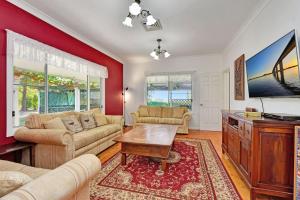 a living room with a red wall at Tabitha Hill Estate close to wineries and nature in Bellbird