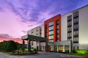 a hotel building with a sunset in the background at Hyatt Place Greensboro in Greensboro