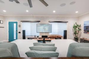un soggiorno con mobili bianchi e TV a schermo piatto di Luxury 6BR/5BA + Hot Tub near DT a San Antonio