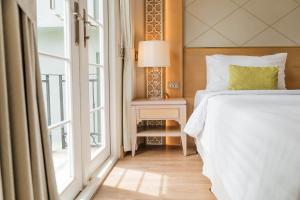 a bedroom with a bed and a window at La Petite Salil Sukhumvit Thonglor 1 in Bangkok