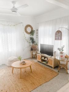 a living room with a tv and a coffee table at Beach Bungalow Yeppoon in Yeppoon