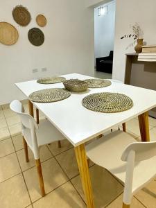 a white table with white chairs and plates on it at Departamento Cristo del Portezuelo I in Chilecito