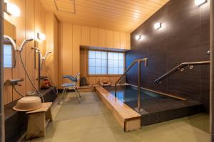 a bathroom with a swimming pool and a tub at サポートイン南知多 in Utsumi