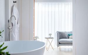 a bathroom with a bath tub and a chair at Guilin Bonjour Boutique Hotel in Guilin