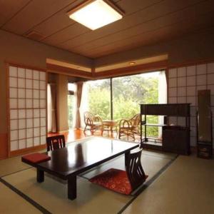 salon ze stołem i krzesłami oraz oknem w obiekcie Ryokan Ichinomatsu w mieście Hakodate