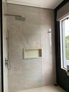 a shower with a glass door in a bathroom at Habitación en suite in Fernando de la Mora