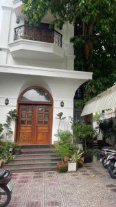 a building with a wooden door and a balcony at Mận Đào Villa in Ho Chi Minh City