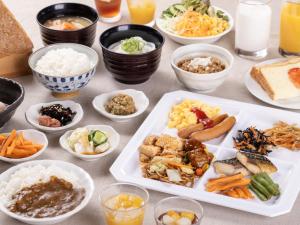 stół z talerzami żywności i miskami żywności w obiekcie Hotel Wing International Sukagawa w mieście Sukagawa