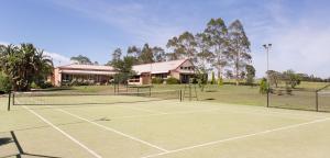 un court de tennis en face d'un bâtiment dans l'établissement Bluebush Estate, à Lovedale
