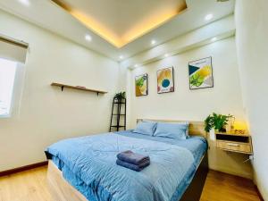 Schlafzimmer mit einem Bett mit blauer Decke in der Unterkunft Ule Home in Ho-Chi-Minh-Stadt
