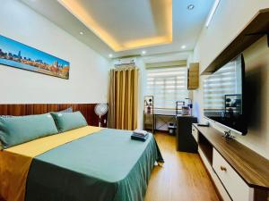 ein Schlafzimmer mit einem großen Bett und einem Flachbild-TV in der Unterkunft Ule Home in Ho-Chi-Minh-Stadt