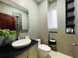 a bathroom with a white sink and a toilet at Ule Home in Ho Chi Minh City