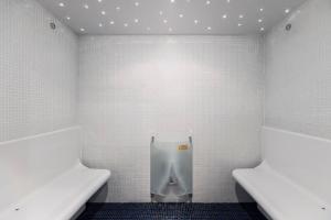 a bathroom with a urinal in a white tiled wall at Villa Rukatunturi in Kuusamo