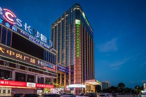 a tall building with neon signs in a city at Holiday Inn Express - Liuyang Development Zone, an IHG Hotel in Liuyang