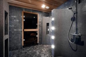 a bathroom with a shower with a glass door at Villa Rukatunturi in Kuusamo