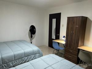 1 dormitorio con cama, escritorio y tocador en Corazón Sabana en San José