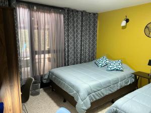 a small bedroom with a bed and a window at Corazón Sabana in San José