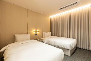 Postel nebo postele na pokoji v ubytování Hotel The Grang Seogwipo