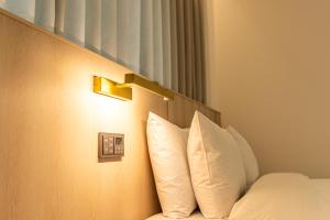 ソギポにあるHotel The Grang Seogwipoのホテルルーム(白い枕付きのベッド付)