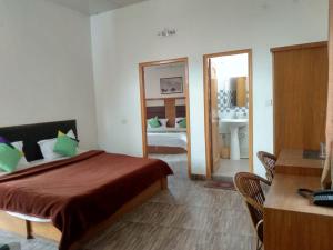 カングラにあるAtithi Hotelのベッドルーム1室(ベッド1台付)、バスルーム(シンク付)