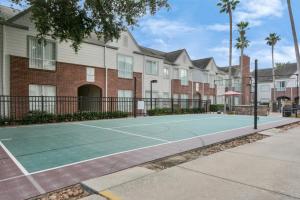 a tennis court in front of a building at NASA Solace Getaway-King Bed in Houston