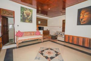烏布的住宿－Dewata ubud，客厅配有沙发和墙上的绘画