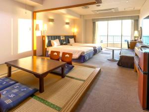 a hotel room with a bed and a table at Hotel Resonex Nago in Nago