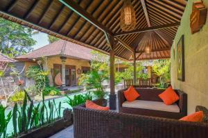 an outdoor patio with a wooden pergola at Dewata ubud in Ubud