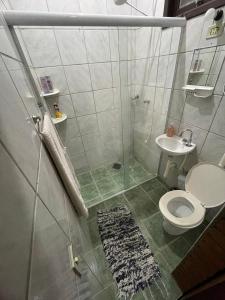 ein Bad mit einer Dusche, einem WC und einem Waschbecken in der Unterkunft Casa Rústica Alemã - 50m da praia in Ubatuba