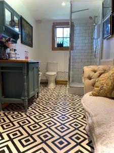 a bathroom with a shower and a couch at Spacious Cabin with Private Hot Tub, and Private Pool, in 5 Acres - intimate Special stay For 2 Adults - plus 1 child under 2 and up to 2 dogs stay for free in Downham