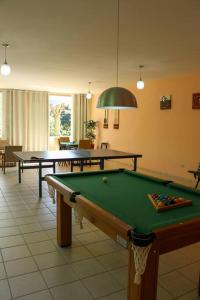 a pool table in a room with two tables at Recanto dos Beija flores, Chalé lantana b in Monte Alegre do Sul