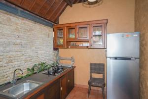 uma cozinha com um frigorífico de aço inoxidável e um lavatório em Dewata ubud em Ubud