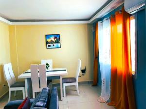 una sala da pranzo con tavolo, sedie, tavolo e sedie di Makeena Berry Cosy Mboa -- a Douala