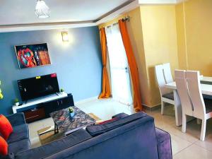 un soggiorno con divano blu e tavolo di Makeena Berry Cosy Mboa -- a Douala