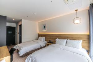 Postel nebo postele na pokoji v ubytování Hotel The Grang Jungmun