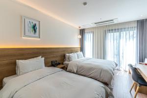 Postel nebo postele na pokoji v ubytování Hotel The Grang Jungmun