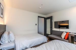 Postel nebo postele na pokoji v ubytování Hotel The Grang Jungmun
