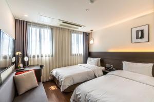 Postel nebo postele na pokoji v ubytování Hotel The Grang Jungmun