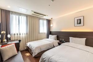 Postel nebo postele na pokoji v ubytování Hotel The Grang Jungmun