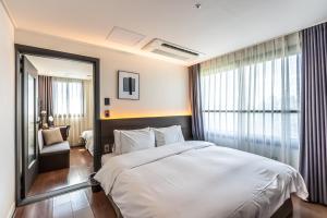Postel nebo postele na pokoji v ubytování Hotel The Grang Jungmun