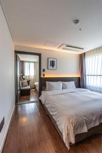 Postel nebo postele na pokoji v ubytování Hotel The Grang Jungmun