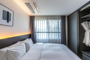 Postel nebo postele na pokoji v ubytování Hotel The Grang Jungmun
