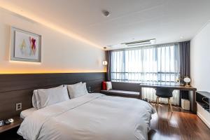 Postel nebo postele na pokoji v ubytování Hotel The Grang Jungmun