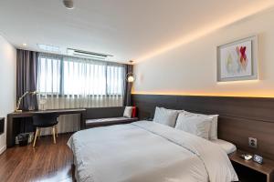 Postel nebo postele na pokoji v ubytování Hotel The Grang Jungmun