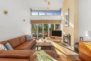 ein Wohnzimmer mit Sofa und Fernseher in der Unterkunft Orions Lookout Vincentia in Vincentia