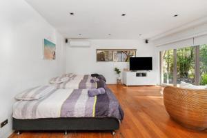 ein Schlafzimmer mit einem Bett, auf dem ein Teddybär liegt in der Unterkunft Orions Lookout Vincentia in Vincentia + 32 Fotos