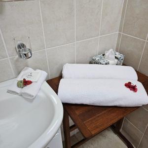 a bathroom with towels on a table next to a sink at House of House Guest House in Stellenbosch