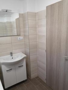 y baño con lavabo blanco y ducha. en Kiss Apartman, en Balatonboglár