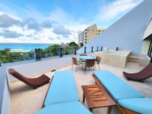 a balcony with chairs and tables and a view of the ocean at Beachfront Getaway Condo in Cancún