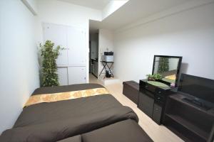 a bedroom with a bed and a mirror and a tv at Carid Shiraishi In front of the station / Vacation STAY 6173 in Sapporo